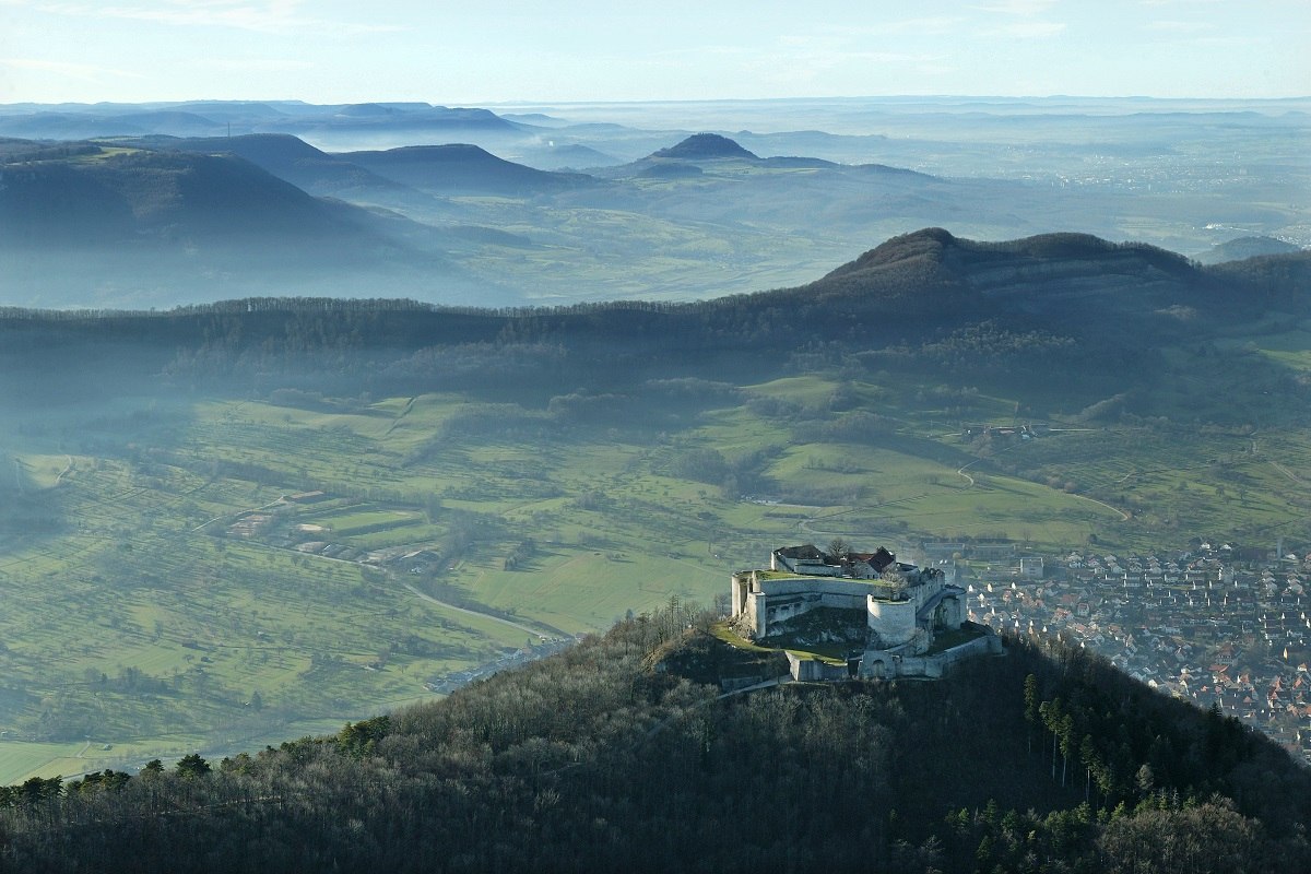 In mystischem blauen und grünen Licht liegt die Burgruine Hohenneuffen vor dem Albtrauf